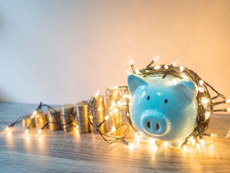 Blue piggy bank with coins pile growth graph and Party lights, Funly saving money for future investment plan and retirement fund concept.の写真素材