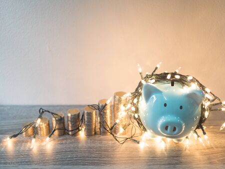 Blue piggy bank with coins pile growth graph and Party lights, Funly saving money for future investment plan and retirement fund concept.の写真素材