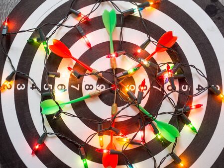 Target six dart focus on bull's eye Dart Board with party light, Funly setting challenging business goals And ready to achieve the goal concept.の写真素材
