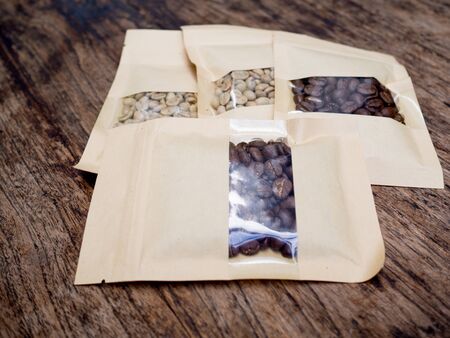 four bags of Coffee beans on the wooden table, ready to give freshness and alongside the...
