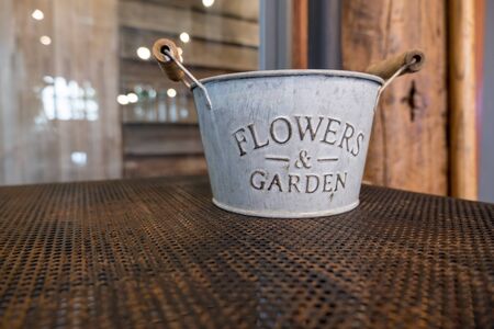Flowers & Garden metal bucket on iron shelf.