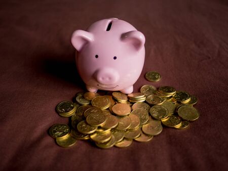 pink piggy bank with coins pile on red background, Saving money for future plan and retirement fund...