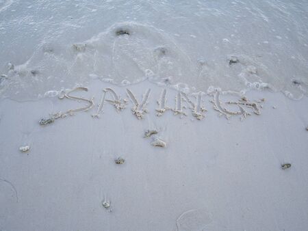 The letters saving were written on the sand with natural beauty.の写真素材