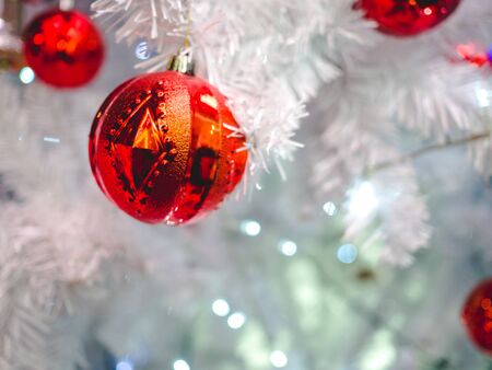 Red christmas balls hanging on a white christmas tree, Have a nice holiday on this x'mas.の写真素材