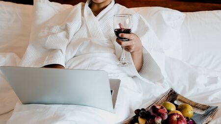 Picture of tourists used laptop and eating fruits on the bed, health food concept.の写真素材