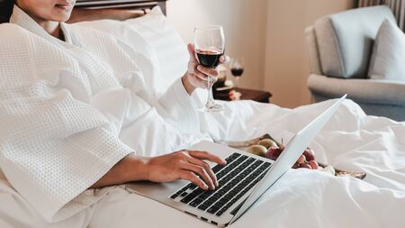 Picture of tourists used laptop and eating fruits on the bed, health food concept.の写真素材