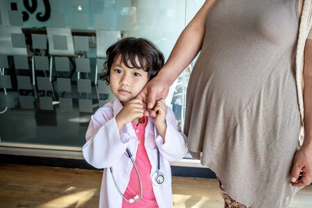 Photo of kid doctor and stethoscope with pregnant mother in the office.の写真素材