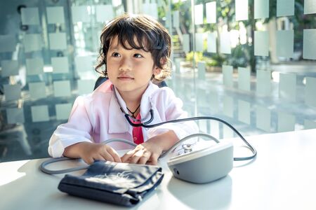 Photo of kid doctor with stethoscope working in the office.の写真素材