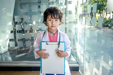 Photo of kid doctor with stethoscope working in the office.の写真素材