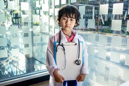 Photo of kid doctor with stethoscope working in the office.の写真素材