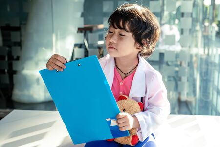Photo of kid doctor with stethoscope working in the office.の写真素材