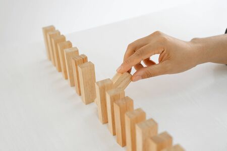 Hand holding blocks wood game, Concept Risk of management and strategy plan, growth business success process and team work.の写真素材