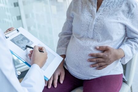 The doctor check the health and advise pregnancy to pregnant women.の写真素材