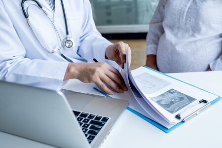The doctor check the health and advise pregnancy to pregnant women.の写真素材