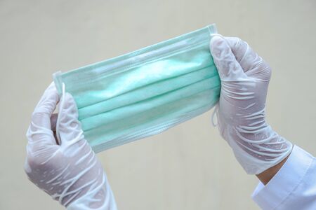 Doctor hands wear rubber gloves and spread a mask, Fight in disaster covid19.の写真素材