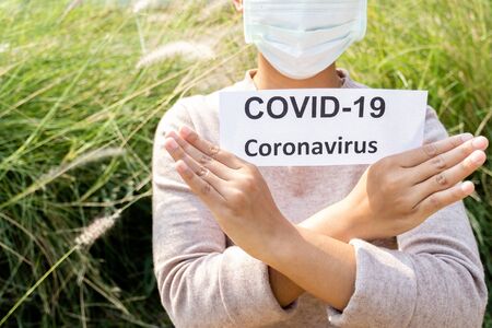 The women hand holding covid19 paper make a symbol fight in disaster covid19, and wearing the mask.の写真素材