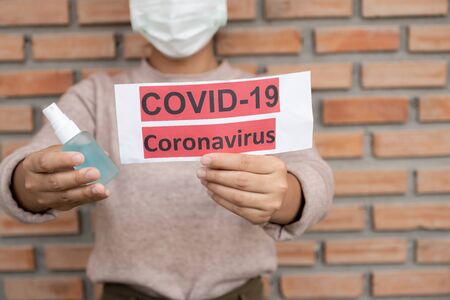 The women hand holding covid19 paper make a symbol fight in disaster covid19, and wearing the mask.の写真素材