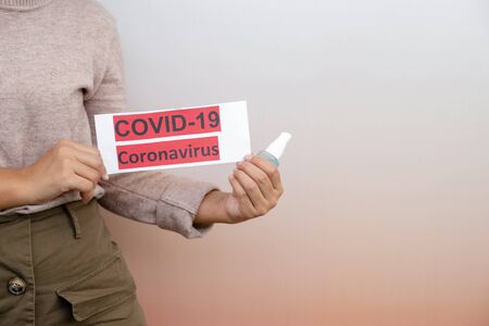 The women hand holding covid19 paper make a symbol fight in disaster covid19, and wearing the mask.の写真素材