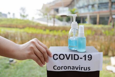 The women hand holding covid19 paper make a symbol fight in disaster covid19 with alcohol gel and spray.の写真素材