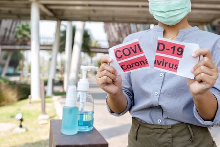The women hand holding covid19 paper make a symbol fight in disaster covid19, and wearing the mask.の写真素材