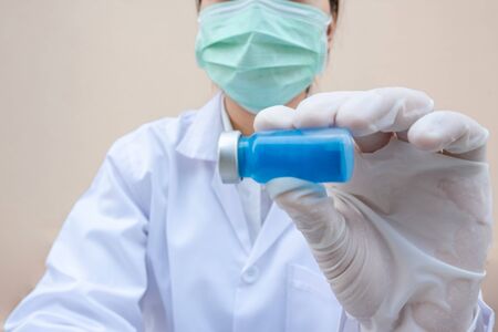 The picture of doctor's hand is holding a blue serum tube.