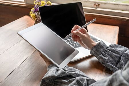 Business woman working at home with her laptop and tablat.