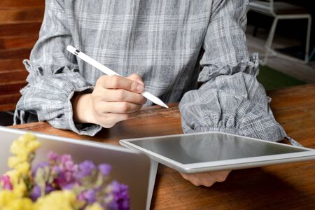 Business woman working at home with her laptop and tablat.