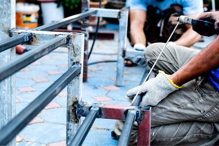 The mechanic is using a welding machine to weld steel.