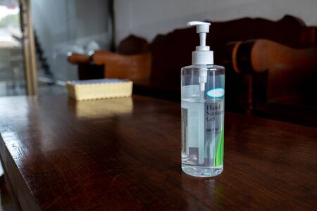 Picture of hand sanitizel alcohol gel placed on a brown wooden floor.の写真素材