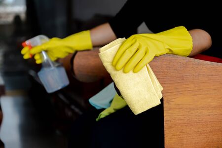 The housekeepers  used cloth and cleaning solution to clean the table and chair.の写真素材