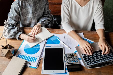 Two business women have analysis the chart, set targets for new management success.