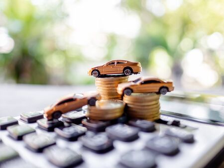 Golden cars with golden coins pile and calculator, business cars, Insurance, rent concept.の写真素材