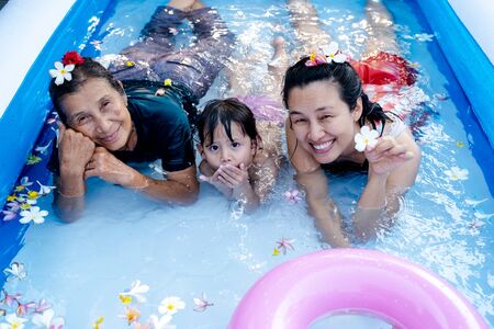 Three generation people swimming in Inflatable Pool at the summer time.の写真素材
