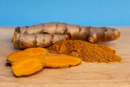 Picture of Turmeric root and turmeric powder on a blue background.の写真素材