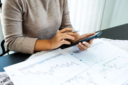 Young women analyze stock graph and report, set targets for online trading management success.