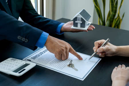 The buyer is signing a contract for business rental, mortgage purchase, or home insurance in front...