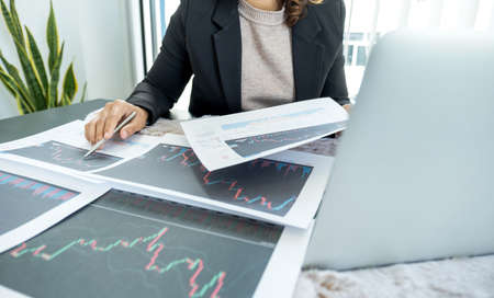 Businesswomen analyze stock graph and report, set targets for online trading management success.の写真素材