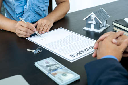 The buyer is signing a contract for business rental, mortgage purchase, or home insurance in front of a real estate agent.の写真素材