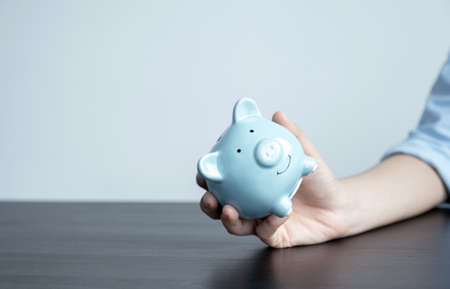 Woman hand holding piggy bank, step up start up business to success, Saving money for future plan and retirement fund concept.の写真素材
