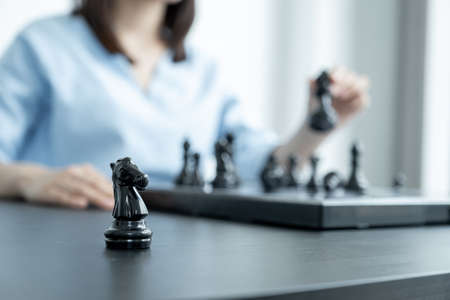 Knight standing in front of people hand move chess with strategy and tactic to win enemy, play battle on board game, business opportunity  competition strategic challenge concept.の写真素材