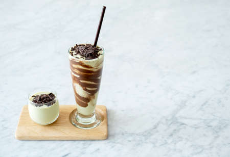 Avocado smoothie shake and chocolate or cacao flakes dessert drink for vegan no milk mousse.