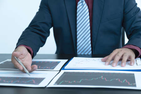 Trader businessmen analyze stock graph and report, set targets for online forex trading market...