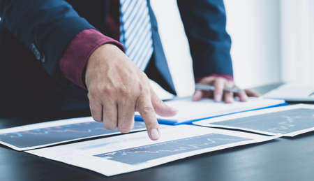 Trader businessmen analyze stock graph and report, set targets for online forex trading market management success.の写真素材