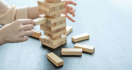 Hand holding blocks wood game, Concept Risk of management and strategy plan, growth business success process and team work.の写真素材