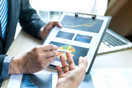 businessmen and businesswomen team meeting to plan strategies to increase business income. Have a brainstorming graph analysis and discussing for the new target success.の写真素材