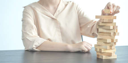 Hand holding blocks wood game, Concept Risk of management and strategy plan, growth business success process and team work.の写真素材