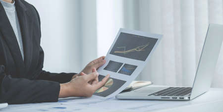 Businesswoman analysis the chart with laptop at the office for setting challenging business goals...