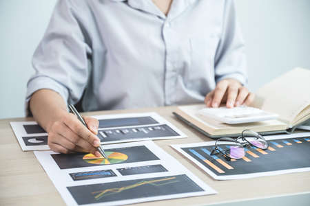 Businesswoman analysis the chart with laptop at the office for setting challenging business goals...
