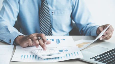Businessman analysis the chart with laptop at the office for setting challenging business goals And...