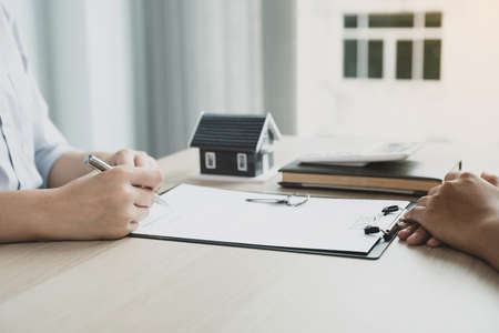 Real estate agent hand holding a pen, point to business contract, rent, buy, mortgage, loan, home insurance.の写真素材